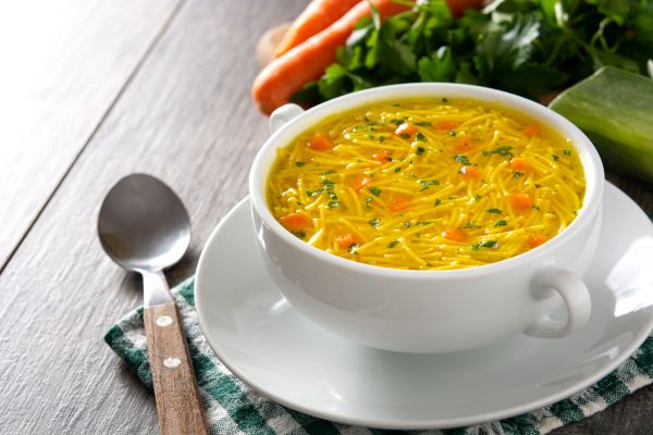 sopa de verduras con pescado servida en lato hondo